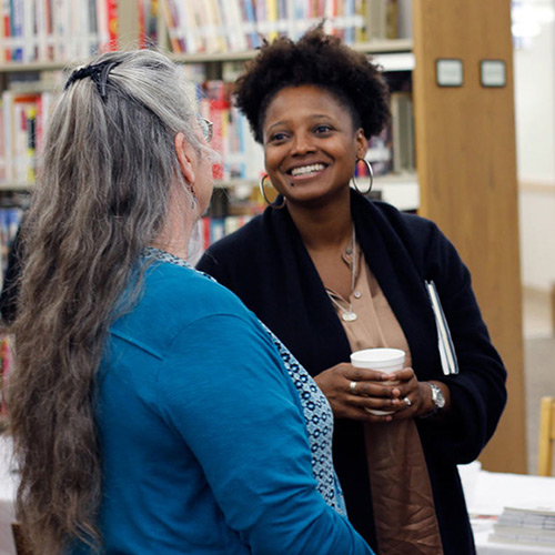 Tracy K. Smith chats with (from left to right) Irene Heinert, Dedi Larue, and Christina Steele (all from Sturgis, SD) before her 'American Conversations' event at the Sturgis Public Library in Sturgis, SD. October 6, 2018. Credit: Ryan Woodard.