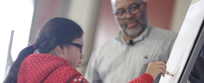 Award-winning illustrator James E. Ransome, co-creator of “Before She Was Harriet” with his wife Lesa Cline-Ransome, takes a student from Harriet Tubman Elementary School (Washington, DC) through a drawing exercise at an event honoring the story and legacy of Harriet Tubman (2/8/2018).