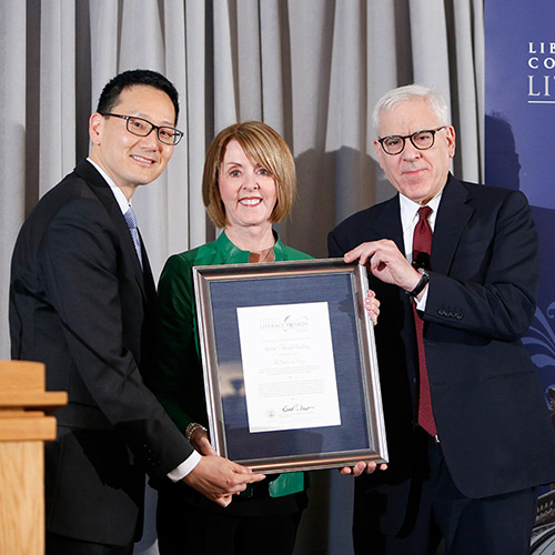 Sally Ann Zoll, representing United Through Reading, receives the 2015 Library of Congress Literacy Awards American Prize, presented by David M. Rubenstein (right) and Acting Librarian of Congress David Mao (left).
